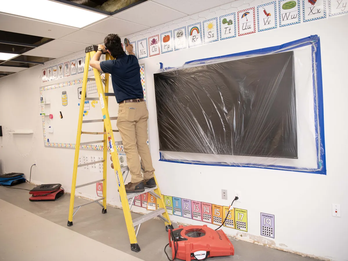 Cavalry crew drying a commercial classroom with air movers along the walls